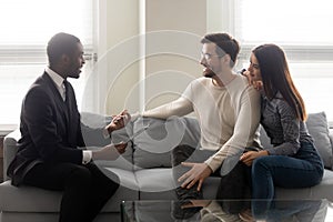 Happy young family couple listening to financial expert offer.