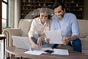 Happy young family couple managing household budget.