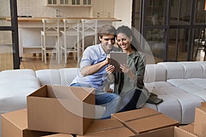 Happy young family couple using digital computer tablet.