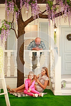 Happy young family with daughter have fun together at home in yard
