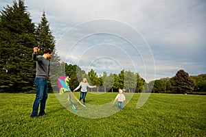 Happy young family with flying a kite.