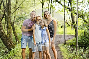 Happy young family in forest having fun together