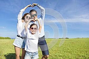 Happy young family forming love shape