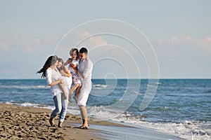 Šťastný mladý rodina mít zábava na pláž 