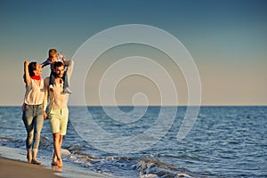 Happy young family have fun on beach run and jump at sunset