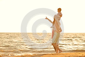 Happy young family have fun on beach run and jump at sunset