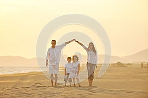 Happy young family have fun on beach at sunset