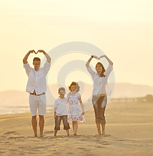 Happy young family have fun on beach at sunset