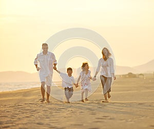 Happy young family have fun on beach at sunset