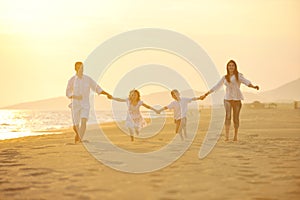 Happy young family have fun on beach at sunset