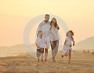 Happy young family have fun on beach at sunset