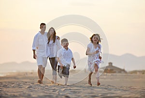 Happy young family have fun on beach at sunset