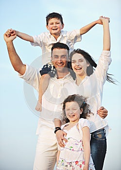 Happy young family have fun on beach at sunset