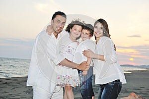 Happy young family have fun on beach at sunset