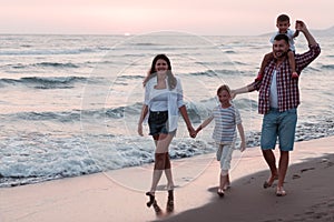 Happy young family have fun and live healthy lifestyle on beach. Selective focus