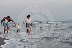 Happy young family have fun and live healthy lifestyle on beach. Selective focus