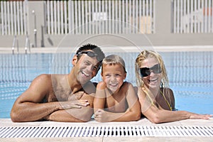 Happy young family have fun on swimming pool