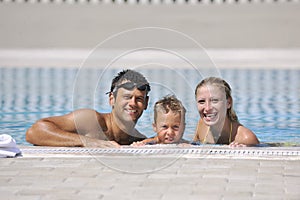 Happy young family have fun on swimming pool