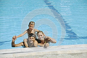 Happy young family have fun on swimming pool