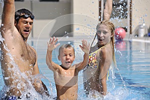 Happy young family have fun on swimming pool