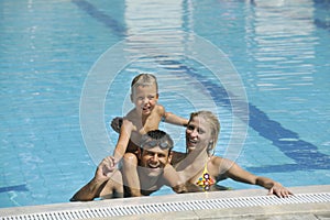 Happy young family have fun on swimming pool