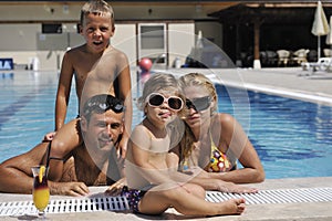 Happy young family have fun on swimming pool