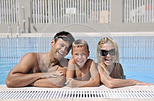 Happy young family have fun on swimming pool