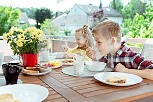 Happy young family having fun during breakfast on terrasse at home