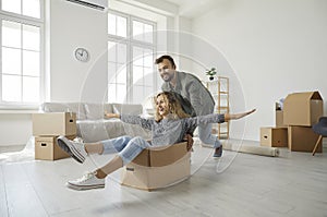 Happy young family having fun in the living room of their new home on moving day