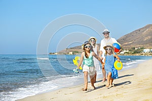 Happy young family having fun running on beach at sunset. Family