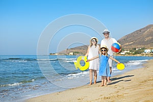 Happy young family having fun running on beach at sunset. Family