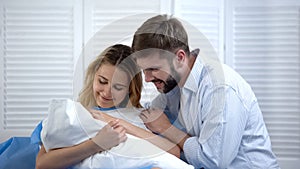 Happy young family holding newborn child, togetherness, labor and delivery