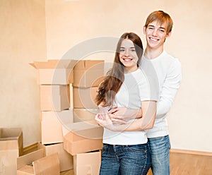 Happy young family hugging on a background of cardboard boxes