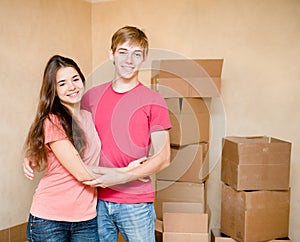 Happy young family hugging on a background of cardboard boxes