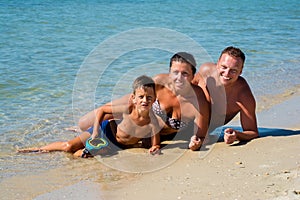 Happy Young Family with Kid Having Fun at Beach.