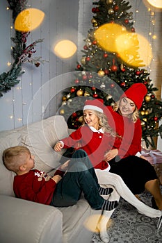 Happy young family with kids having fun celebrating christmas. Christmas time at home.