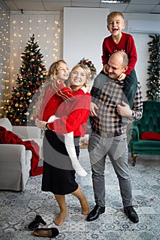 Happy young family with kids having fun celebrating christmas. Christmas time at home.