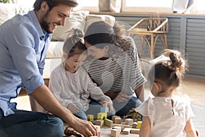 Happy young family with kids playing with bricks