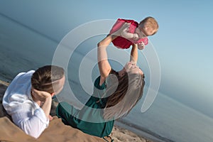 Happy young family with little child, having fun on the beach