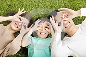 Happy Young Family lying on the grass