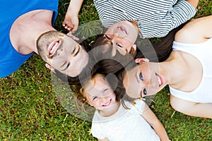 Happy young Family lying on grass