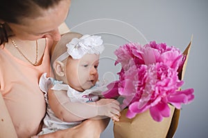 Happy young family. Mom and baby with flowers