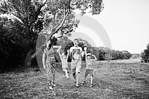 Happy young family: mother, father, two children son on nature having fun