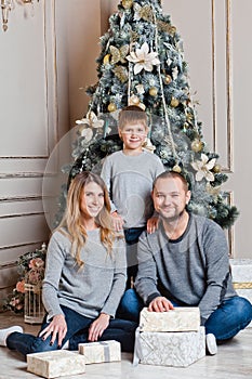 Happy young family with one child holding christmas gift and smiling at camera.happy family mother father and baby at christmas