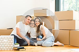 Happy young family, parents daughter and son, unpacking boxes and moving into a new home. funny kids run in with boxes