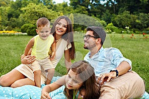 Happy Young Family In Park. Parents And Kids Having Fun, Playing