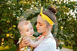 The happy young family during picking apples in a garden outdoors