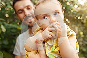 The happy young family during picking apples in a garden outdoors