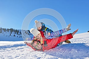 Happy young family playing in fresh snow at beautiful sunny winter day outdoor in nature