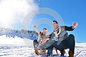 Happy young family playing in fresh snow at beautiful sunny winter day outdoor in nature
